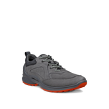 Gray athletic shoe with red sole on a white background