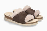 Brown suede slippers with white fur lining on a white background