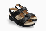 A pair of black leather wedge sandals with double straps and adjustable ankle straps, shown on a light gray background.